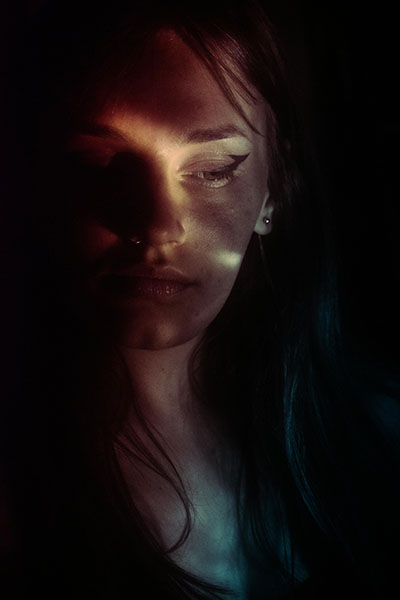 chica en habitacion oscur a con luz tenue y conflicto resuelto con terapeuta biodescodificacion