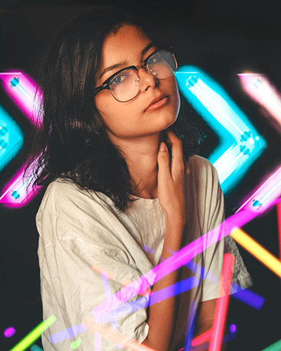 letreros y luces de neon rodean a una chica que consigue gestion emocional superior biodescodificacion