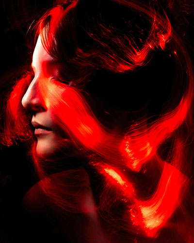 luces rojas de neon sobre rostro de mujer que calla sus emociones segun biodescodificacion bruxismo