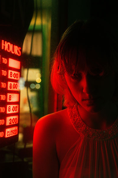 Neon rojo ilumina el rostro de mujer irritada que describe biodescodificacion infeccion de orina