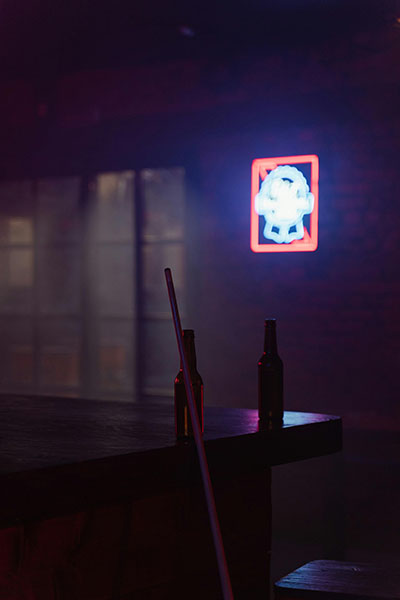 foto oscura de un bar con botellas y tacos al que recurre una persona que sufre adicciones biodescodificacion