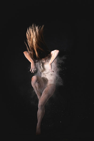 bailarina con polvo blanco representa la ira que explota como significado emocional de los tumores