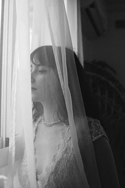 chica mirando por la ventana tapada por cortina encuentra mentira desvelada biodescodificacion