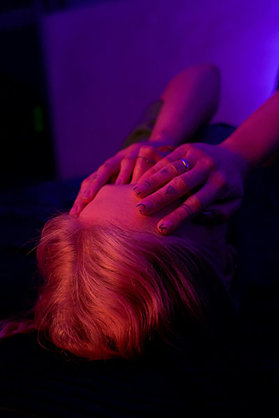 habitacion luces neon tenues con mujer tapando la cara con las manos ataques de panico desde la biodescodificacion