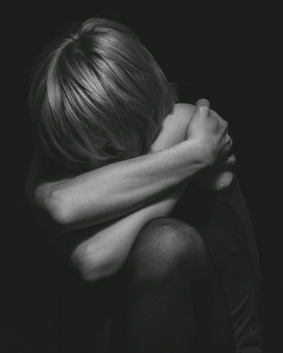 foto blanco y negro con mujer arrodillada preocupada biodescodificacion neumonia significado