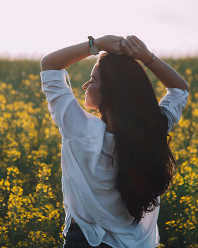 mujer en un prado sonriente libera emociones de la bronquitis con biodescodificacion