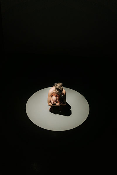 foto artistica luz iluminando a mujer agazapada representa origen emocional del ataque de panico